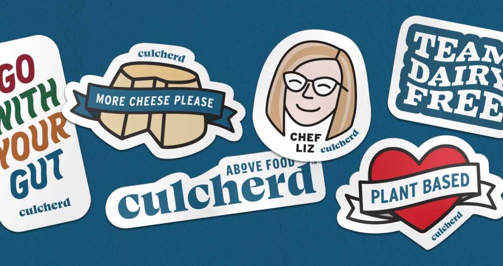 Image of layered stickers on a dark blue background. From left to right, the stickers read "Go With Your Gut" in different colors on a white background, "More Cheese Please" in a ribbon on a cheese round, the Culcherd logo, a simple illustration of Chef Liz's face wearing glasses, white text that reads "Team Dairy Free" in a blue outline, and "Plant Based' in a ribbon on a red heart.
